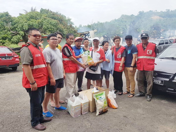 SIMON (empat dari kiri) menyerahkan sumbangan kepada salah seorang mangsa kebakaran.