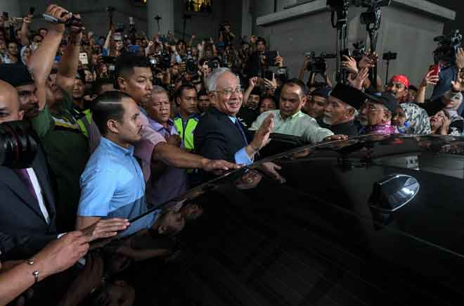  Najib ketika keluar dari Mahkamah Kuala Lumpur semalam selepas didakwa atas pertuduhan berkaitan kemasukan wang RM2.6 billion ke akaun peribadinya dan kes berkaitan skandal 1MDB. — Gambar Bernama