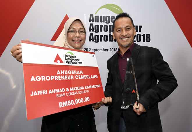  Jaffri (kanan) dan isteri, Mazlina menunjukkan trofi dan replika cek bernilai RM50,000 pada Majlis Anugerah Agropreneur Agrobank 2018 di Hotel Pullman,  kelmarin. — Gambar Bernama