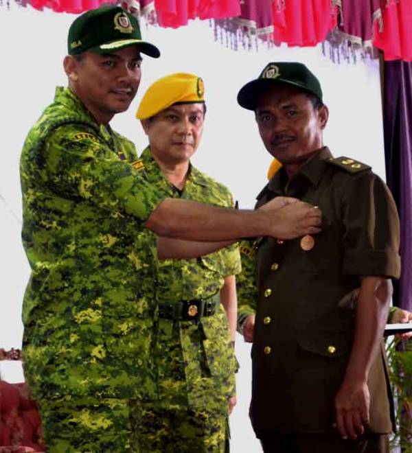  Mohd Azis (kiri) menyempurnakan pemakaian pingat kepada salah seorang Pegawai Bersekutu Bridged Rela Siswa (Relasis) Malaysia di Akademi Latihan Rela di Akademi Latihan Rela, Melaka, semalam. — Gambar Bernama