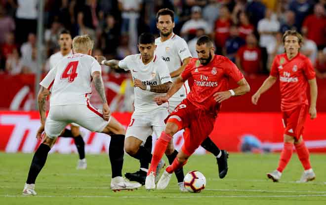  Benzema (kanan) diasak hebat oleh dua pemain Sevilla ketika beraksi pada perlawanan La Liga di Stadium Ramon Sanchez Pizjuan, Seville Rabu lepas. — Gambar Reuters