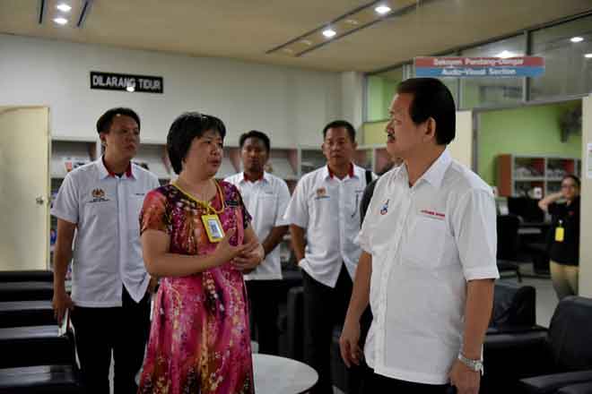   Stephen Wong Tien Fatt (kanan) diberikan penerangan oleh Ketua Perpustakaan Wilayah Sandakan Cecilia Chai Yee Jet (dua kiri) ketika meninjau kerja pembaikan pendingin hawa Perpustakaan Sandakan, semalam. — Gambar Bernama