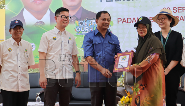 JAUJAN (tengah) menyampaikan anugerah kepada salah satu penerima, turut kelihatan ialah Junz (dua kiri), Christina (kanan) dan Daud (kiri).