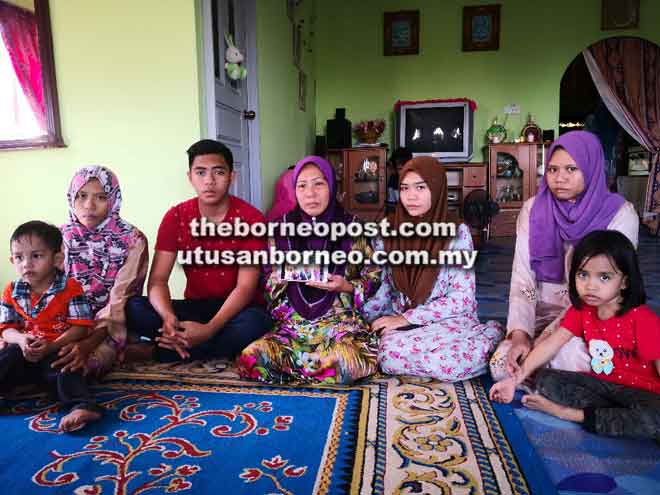  Razaiah (dua kiri) bersama adik-beradik dan anak saudara arwah Mazlan ditemui pemberita di kediaman makciknya di Kampung Batu Tinagat Tawau. Turut kelihatan, ibu arwah, Asmah Abdalis yang memegang foto kenangan mereka sekeluarga.