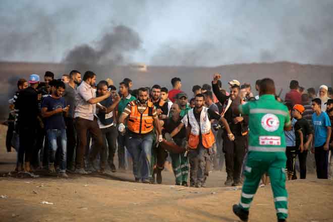  Pemberontak yang cedera dalam pertelingkahan dengan pasukan keselamatan dibawa keluar di  Jabalia, utara semenanjung Gaza, kelmarin. — Gambar AFP