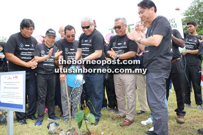  Awang Tengah menyiram pokok yang ditanamnya di tapak ‘Takasago-UNIMAS Educational Forest’ sambil disaksi (dari kiri) Malcom dan Naroden serta tetamu kehormat lain.