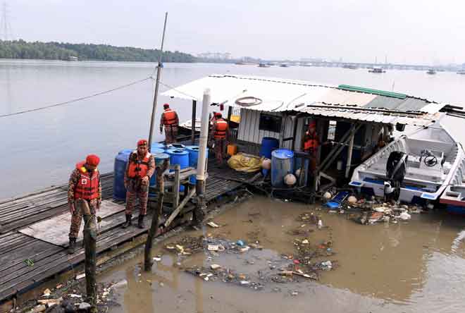  Anggota Bomba dan Penyelamat Malaysia (JBPM) Pelabuhan Klang memantau keadaan air laut di jeti nelayan berikutan fenomena air pasang besar di Kampung Nelayan Telok Gong semalam. — Gambar Bernama