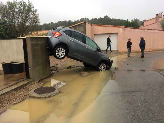  Penduduk berdiri dekat kereta yang dihanyutkan oleh banjir kilat di selatan Perancis kelmarin. — Gambar AFP