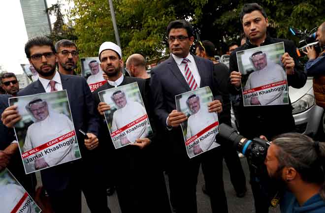  Aktivis hak asasi dan rakan Khashoggi memegang gambar beliau ketika demonstrasi di luar Konsulat Arab Saudi di Istanbul, Turki pada 8 Oktober lalu. — Gambar Reuters