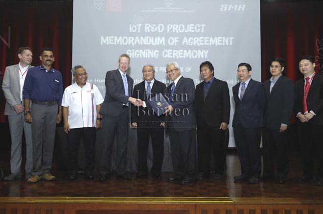 Rektor UiTM Kampus Sarawak Datuk Dr Jamil Hamali menerima dokumen daripada Timbalan Naib Canselor Swinburne Profesor John Wilson (tiga kiri) sambil disaksikan Awang Tengah (empat kiri) dan yang lain. - Gambar Chimon Upon