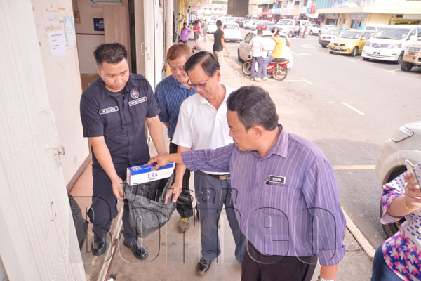 PETER Hii bersama Pegawai Penguatkuasa MPS Irman Tajuddin Edy memeriksa rokok yang dijumpai diletak di tepi dinding bangunan.