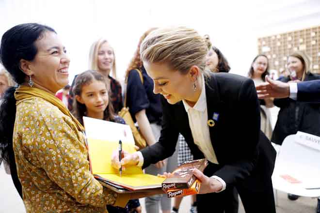  Amber Heard menandatangani autograf dengan coklat Swiss di tangannya, selepas berucap mengenai pengalaman hak asasinya di Geneva pada 22 Oktober lepas. — Gambar Reuters