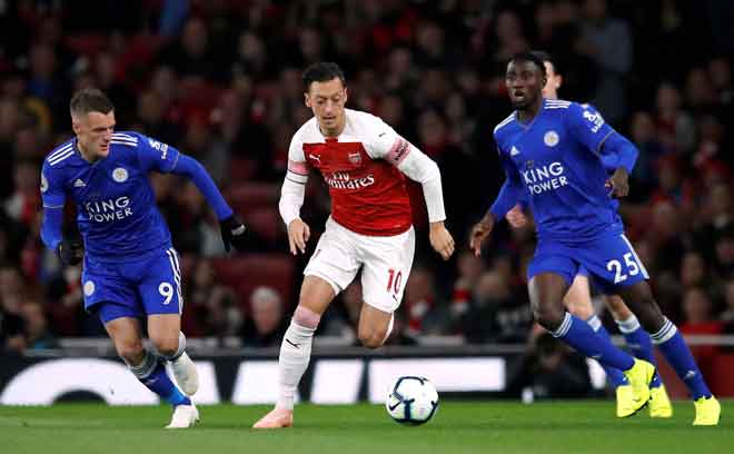  Ozil (tengah) lakukan gerakan menarik ketika bersaing dengan Vardy pada perlawanan liga di Stadium Emirates, London   lepas. — Gambar Reuters