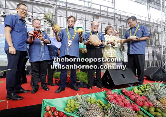  Abang Johari (tiga kiri) menunjukkan buah nanas dan terung Dayak selepas melakukan simbolik pelancaran Sarawak AgroFest 2018 di pekarangan PCC di Kuching semalam. Turut kelihatan (dari kiri) Abdullah, Sagah, Uggah dan Dr Abdul Rahman (kiri). — Gambar Chimon Upon