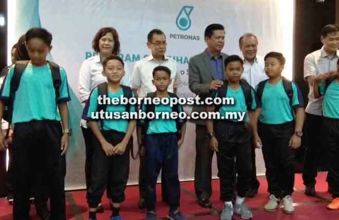  (Dari kanan) Lau, Shamsur, Majang Mataip dan Puyang menyampaikan beg sandang kepada murid simbolik Program Sentuhan Ilmu Petronas ‘Back to School 2018’ Peringkat Negeri Sarawak, semalam.