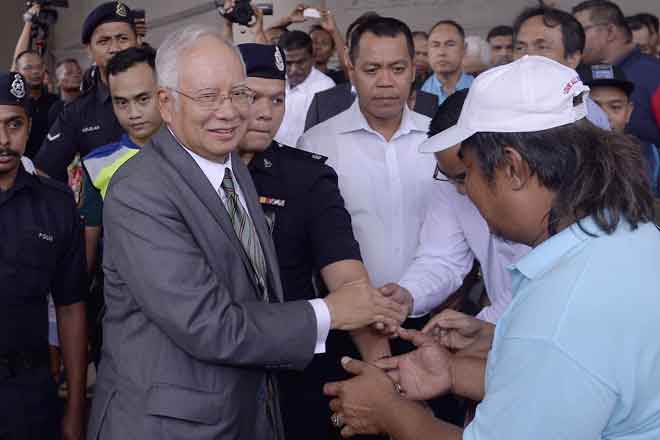  Najib bersalaman dengan ratusan penyokongnya yang menunggu beliau di lobi sebaik keluar dari Mahkamah Tinggi Kuala Lumpur semalam.  — Gambar Bernama