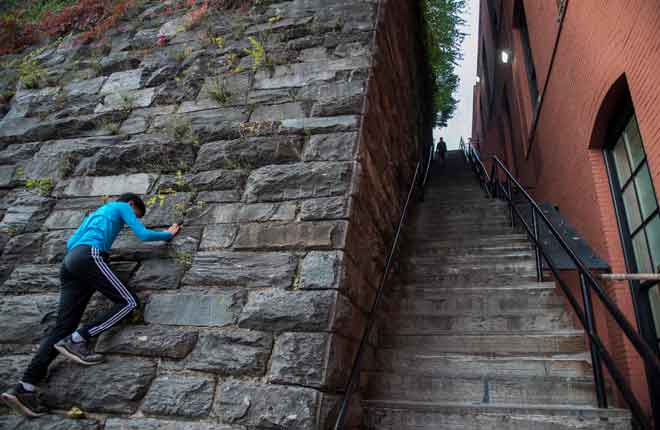  Seorang budak lelaki memanjat dinding dekat anak tangga yang menjadi terkenal oleh filem 1973 ‘The Exorcist’ di Georgetown, Washington DC, Amerika Syarikat. — Gambar AFP