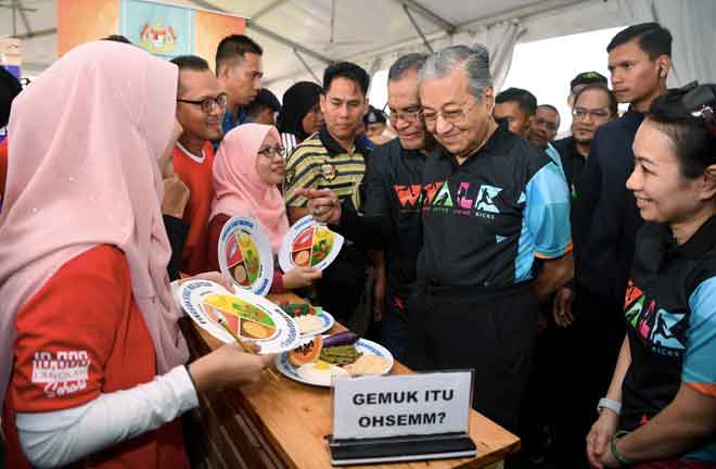  Dr Mahathir (dua kanan) melawat ruang pameran pemakanan seimbang selepas melancarkan Kempen Gaya Hidup Aktif (WALK) 2018 di Setia Alam dekat Shah Alam, semalam. Turut hadir Menteri Kesihatan Datuk Seri Dr Dzulkefly Ahmad (tiga kanan). — Gambar Bernama