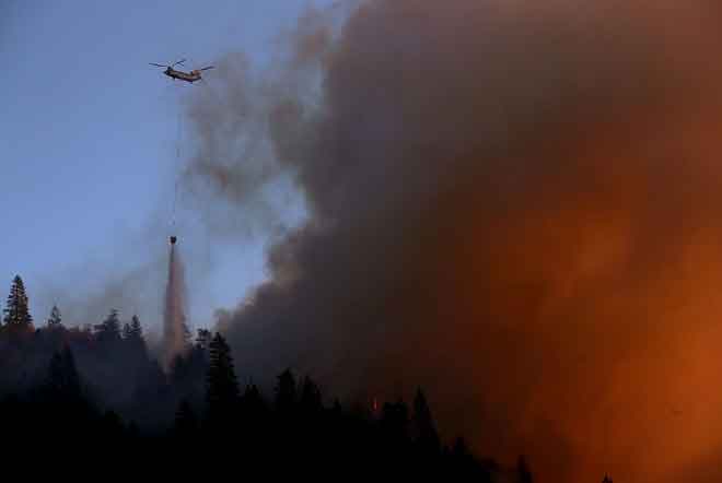  Sebuah helikopter mencurahkan air ke atas kebakaran hutan ‘Camp Fire’ di bukit dekat Cresta, California kelmarin. — Gambar AFP