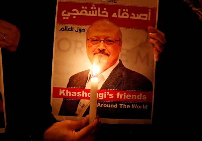  Seorang penunjuk perasaan membawa poster dengan gambar Khashoggi                di luar konsulat Arab Saudi di Istanbul, Turki pada 25 Oktober lepas. — Gambar Reuters