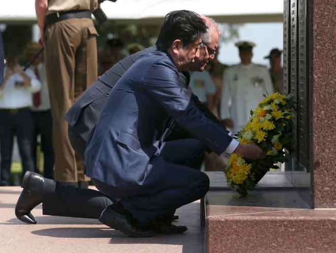  Abe dan Morrison meletak kalungan bunga di tugu peringatan perang, Darwin Cenotaph, di Darwin, Australia semalam. — Gambar AFP