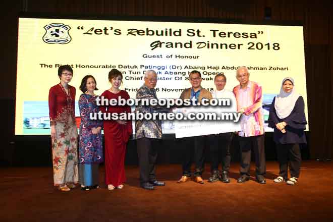  Manyin menyampaikan peruntukan berjumlah RM500,000 kepada Thomas untuk dana projek Bina Semula SMK St Teresa Kuching pada majlis ‘Lets Rebuild St Teresa’ Grand Dinner 2018 di Kuching malam kelmarin. — Gambar Muhammad Rais Sanusi