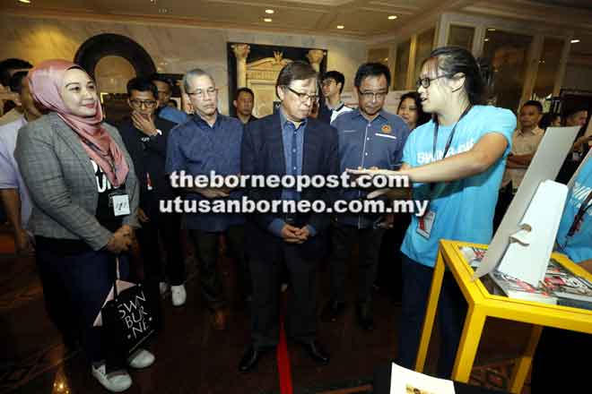  Abang Johari mendengar penjelasan belia yang turut terlibat dengan pameran produk sempena Program ‘Outreach The World’ TEDxKenyalang di DUN lama. Turut kelihatan Karim (dua kanan), Ahli Parlimen Petra Jaya Datuk Seri Fadillah Yusof (tiga kiri) dan Kurator TEDxKenyalang Zaiwin Kassim (dua kiri).