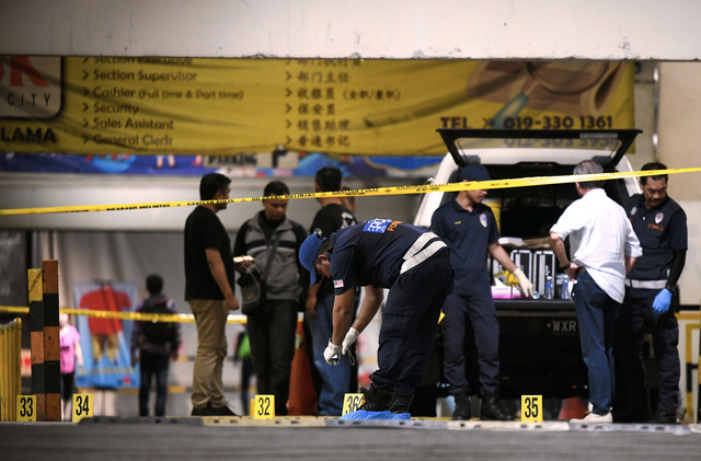 Unit Forensik memeriksa kawasan lima penyamun yang ditembak mati selepas merompak kedai emas di pasar raya di Jalan Kuchai Lama, Kuala Lumpur hari ini.