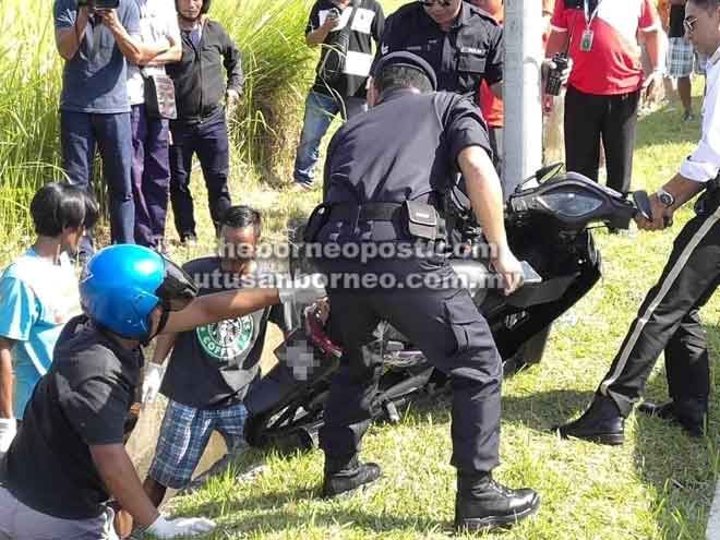  Orang ramai membantu polis mengangkat motosikal yang ditunggang mangsa dari dalam parit tersebut.