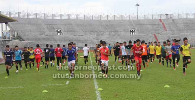  Pemain-pemain memanaskan badan pada sesi ujian hari pertama pemilihan pemain-pemain Sarawak di Stadium Negeri, Petra Jaya semalam.