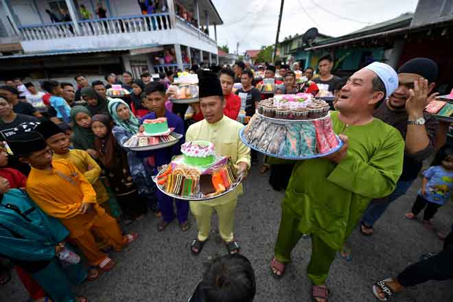  Penduduk kampung membawa talam berisi kek serta kuih-kuih asli yang dipanggil ‘Palak Kuih’ di Masjid Bumiputera Kampung Sebandi Ulu sempena sambutan Maulidur Rasul. —  Gambar Bernama