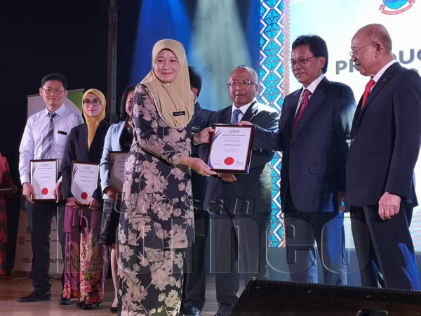 SHAFIE (tengah) bersama tetamu kehormat yang lain menunjukkan buku  'Manual Dealing with Construction Permits (DCP) Dewan Bandaraya Kota KInabalu (DBKK)' selepas melancarkannya pada seminar berkenaan.