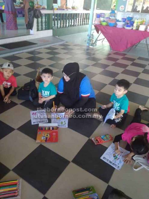  Jawatankuasa Jiran Wanita Noratijah Bakar duduk bersama kanak-kanak yang menyertai pertandingan mewarna.