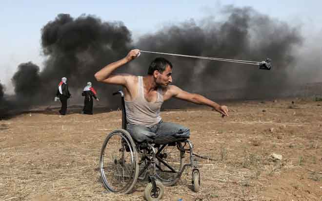  Penduduk Palestin berusia 29 tahun, Saber al-Ashkar, melontar batu sewaktu pertelingkahan dengan tentera Israel di sepanjang sempadan dengan semenanjung Gaza, ke timur Kota Gaza, pada 11 Mei lepas, ketika penduduk Palestin berdemonstrasi bagi menuntut hak untuk kembali ke tanah air mereka yang bersejarah di bumi yang kini dikenali sebagai Israel. — Gambar AFP