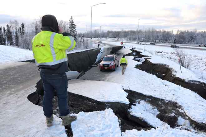  Sebuah kenderaan terkandas dalam runtuhan jalan raya berdekatan lapangan terbang selepas gempa bumi melanda di Anchorage, Alaska di Amerika Syarikat kelmarin. — Gambar Reuters