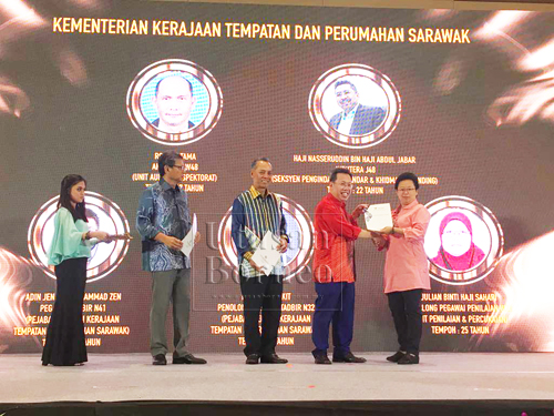 Dr Sim menyampaikan APC 2017 kepada salah seorang pegawai pada majlis anugerah Kementerian Kerajaan Tempatan dan Perumahan yang diadakan di Kuching, malam tadi