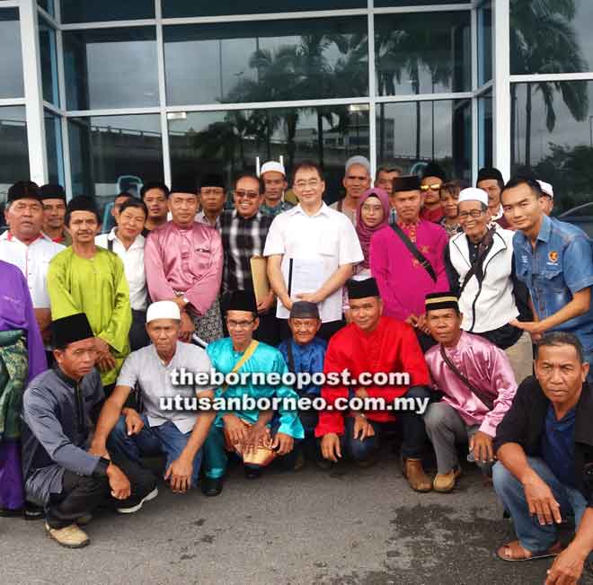  Ng (berdiri lima kanan) begulai enggau peranak Kampung Lubok Bunting enggau genturung pendiau bukai ke bisi kena keruga ba isu tanah.