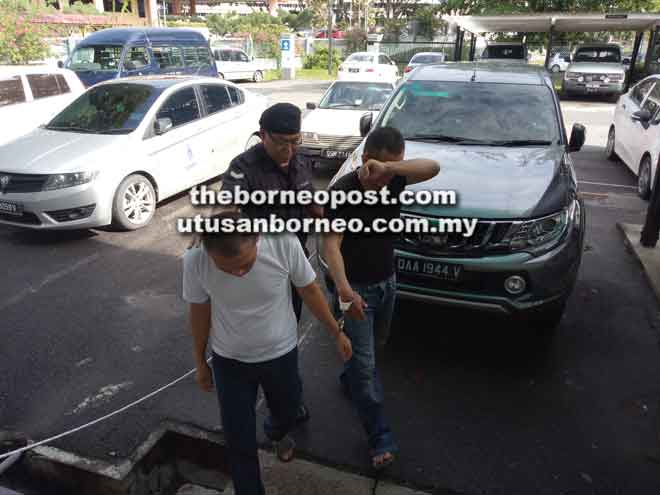  Philip (kiri) dibawa keluar dari lokap Kompleks Mahkamah Sibu semalam untuk dihadapkan di Mahkamah Sesyen.