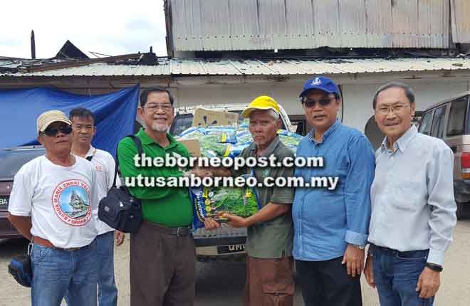  Tuai Rumah Usek (tiga kanan) nerima bantu barang pemakai ari Monsignor Francis Kulleh (dua kiba). Nyempulang iya (ari kanan) Alexius, Marcus enggau Henry.