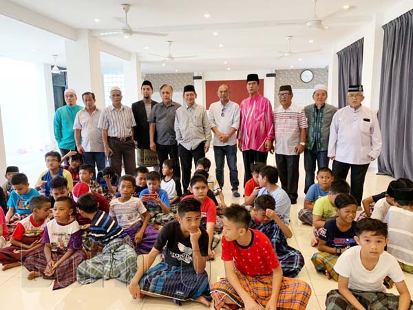 AG. Husaini (berdiri, enam kiri) bersama Jawatankuasa Masjid Al-Kauthar dan tetamu jemputan merakamkan kenangan bersama kanak-kanak yang menyertai program berkhatan.