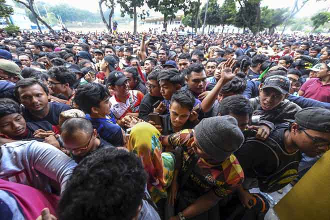  Antara gelagat penyokong pasukan Malaysia ketika berasak bagi mendapatkan tiket menjelang Perlawanan Akhir Piala AFF Suzuki 2018 di Stadium Bukit Jalil, semalam. — Gambar Bernama