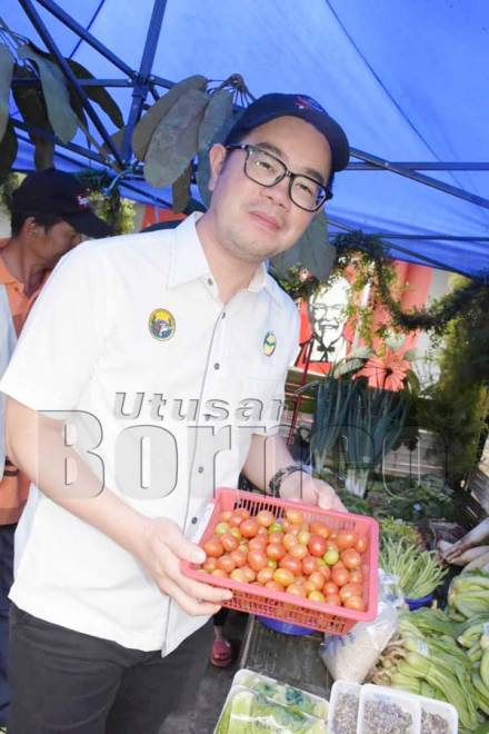JUNZ menunjukkan sayur-sayuran segar di pasar tani yang dibuka sempena sambutan Pesta Kobis di Kg Kiau, Kundasang.