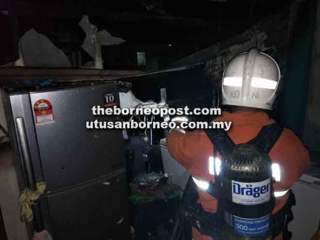  Seorang anggota bomba kelihatan memeriksa rumah mangsa bagi memastikan tiada lagi sisa kebakaran.  
