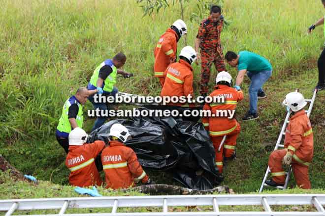  Anggota bomba dan polis berusaha mengeluarkan mayat mangsa.