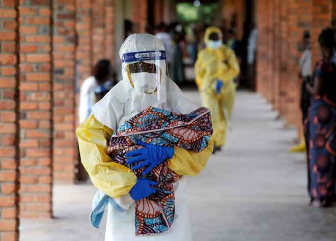  Seorang pekerja kesihatan membawa seorang bayi yang disyaki           dijangkiti virus Ebola di sebuah hospital di Oicha, Congo pada 6 Disember lepas. — Gambar Reuters