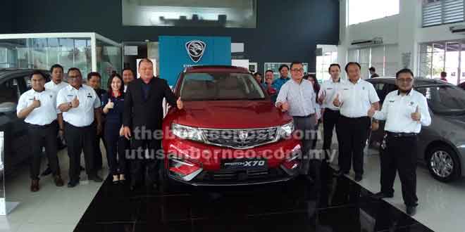  Ahmadi (barisan hadapan, tiga kanan) bersama Pengarah KH Motor Sdn Bhd, Wong Park Sii (barisan hadapan, empat kiri)  dan kakitangan jualannya memperkenalkan Proton X70 semasa majlis pelancarannya di Pusat 3S mereka di Kota Samarahan, semalam.