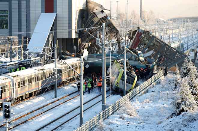  Anggota penyelamat memeriksa bangkai kereta api selepas nahas berlaku di Ankara, Turki pada Khamis. — Gambar Reuters