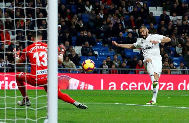  Benzema (kanan) melepaskan rembatan sebelum menjaringkan gol pertama Real ketika beraksi pada perlawanan La Liga Sepanyol menentang Rayo Vallecano di Stadium Santiago Bernabeu, Madrid Sabtu lepas. — Gambar Reuters