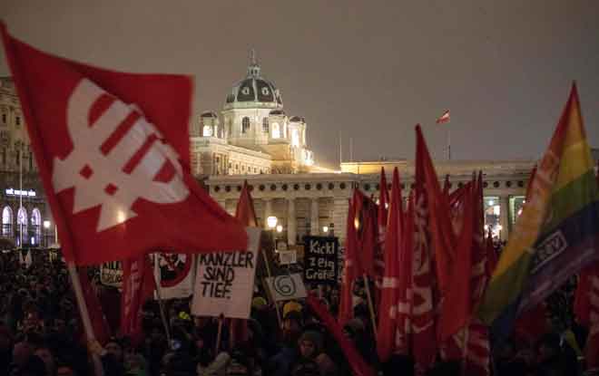  Seorang penunjuk perasaan membawa bendera SPOe semasa menyertai protes di Heldenplatz di Vienna, kelmarin. — Gambar AFP