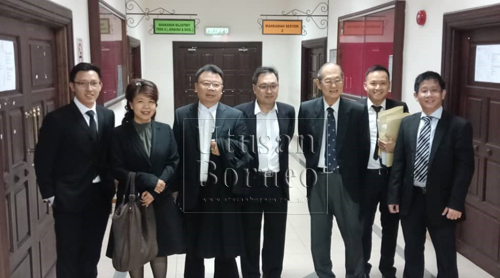 Chong (tengah) dan Tan (kanan) bersama peguam-peguam dan ahli-ahli DAP Sarawak termasuk ADUN Pending Violet Yong dan bapa Chong, Siew Chiang di mahkamah di Petra Jaya di sini, hari ini. 